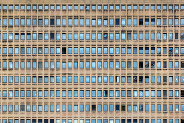 Repeated pattern of a high buidling facade with windows and frame in crowded urban life