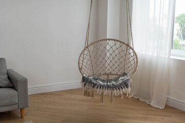 Hanging home rope swing in a Scandinavian interior. The concept of home life, hugge, home comfort.