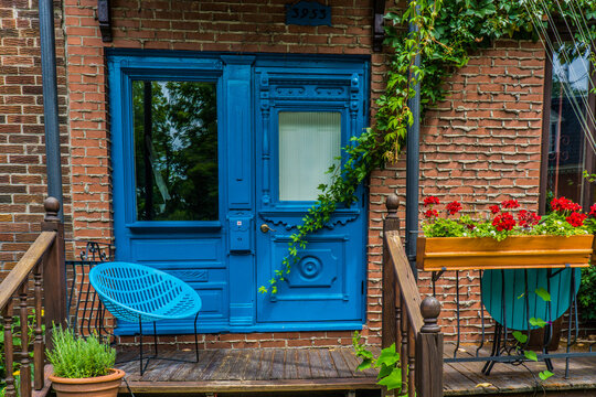 Blue Entrance Door, Brick Wall And Porch, Typical Facade Of A Duplex In Montreal Plateau Mont Royal Neighborhood