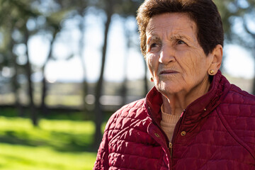 90 year old senior woman sad and looking at the sky thoughtfully.