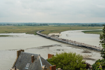 The arrival trail to the famous Mont Saint-Michel Abbey at high tide in the Manche department, Normandy region, France