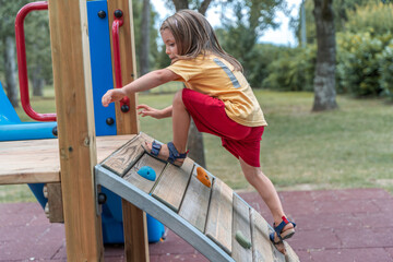 cute little girl have fun climbing a wooden structure in a playground