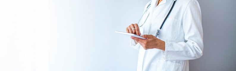 Cropped shot of a female doctor using a digital tablet. Close up of woman doctor hands using...