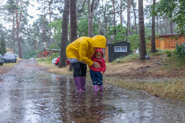 Unwetter - Nach heftigen Regen stehen Frau und Kind in einer Pfütze