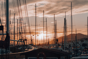 Beautiful sunset view of a marina. Boats and seaside town silhouette landscape.