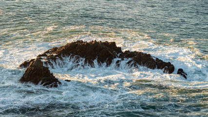 Roca siendo golpeada por las olas