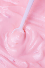 Macro Yogurt,Strawberry frozen yogurt background close up. Strawberry ice cream texture close up. Top view. Pink fruit ice cream background with small pieces of berries