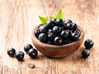 Sweet black currants berry on wooden backgrounds