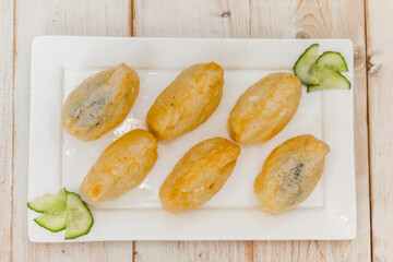 Top view of Japanese inari-zushi with rice and tofu on a white plate