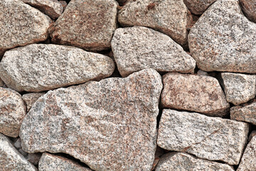 Fototapeta premium Wall with gray and brown irregular different sized and shaped stones