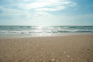 Fototapeta na wymiar Panoramic shot of an ocean waves, beautiful sand sparkling at the sun