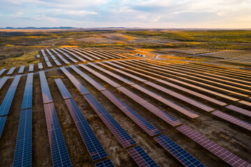 Massive solar power plant at sunset. Hundreds of moving solar panels ready to provide clean energy. Talasol plant. Drone aerial picture. Blue, purple and yellow tones.