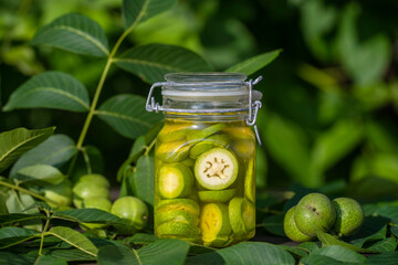 Sliced unripe walnuts in alcohol in a jar, to prepare homemade tincture, close up