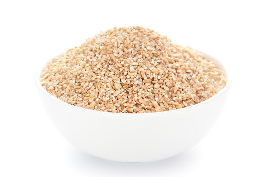 Close-Up of organic broken wheat (dalia or daliya ) roasted  in white ceramic bowl over white background