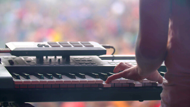 man with synthesizer plays music on the concert