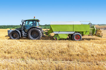 Tractor with straw baler on the harvested grain field 5615