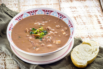 Brazilian bean broth or soup with vegetables and meat, called bean broth, slice of bread on the side