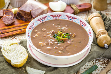 Brazilian bean broth or soup with vegetables and meat, called bean broth, slice of bread on the side