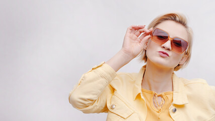 Carefree girl wearing sunglasses. Isolated girl over white background studio. The girl is dressed...