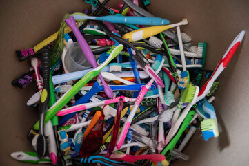 A close-up of many used plastic toothbrushes collected for recycling.