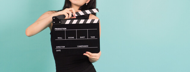 Black clapper board or movie clapperboard in young woman's hand .it use in video production ,film,...