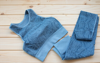 Sport woman clothes on wooden background.