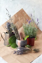 Fresh blooming lavender in a pot and bunches of dried flowers on the table on paper for packaging, flower seedlings, decorate a gift