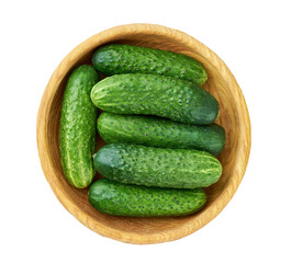 Fresh cucumbers  in a wooden bowl isolated on white background, top view.