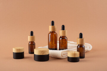 Eco friendly washcloth, amber glass dropper bottles different sizes and jars with bamboo lid. Zero waste concept on beige background. Skincare natural cosmetic. Beauty concept for face body