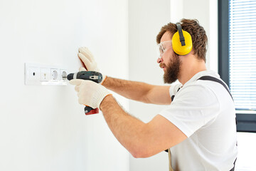 Sockets installation. Caucasian repairman setting new sockets in living room. renovation concept....