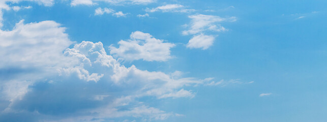 Obraz premium White clouds on a blue sky in sunny weather, panorama