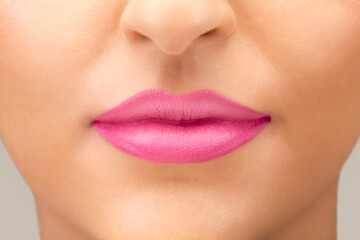 Close up of young caucasian female lips with bright pink lipstick