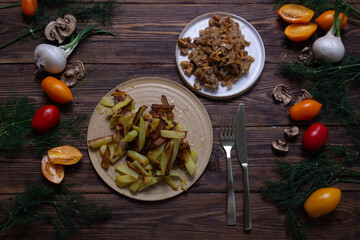 Russian cuisine fried potatoes with mushrooms on a wooden table