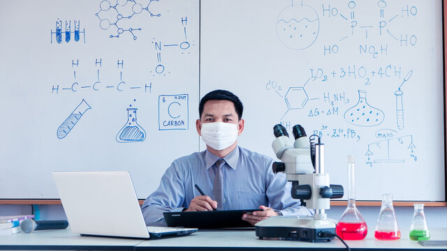 Teacher is teaching science classes online during lockdown due to COVID-19 pandemic with wearing face mask