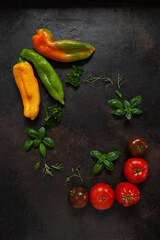Close-up photo of fresh farm organic vegetables and greenery. Top view on dark concrete background