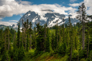 Mt. Shuksan, Washington. Shuksan rises in Whatcom County, Washington immediately to the east of Mount Baker. The mountain is a huge, sprawling mass of ridges, pinnacles, and glaciers. 