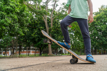 Asian little boy try to play skateboard stand and sit on it . Practice and practice to play.