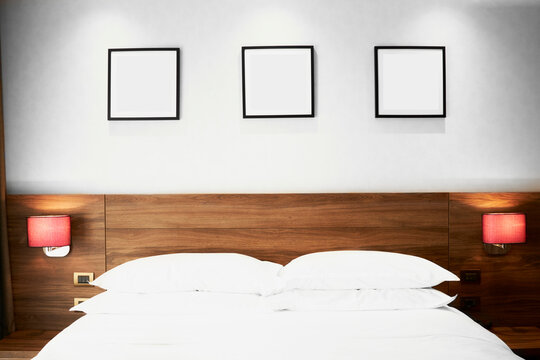 A modern hotel room with three black pictures
