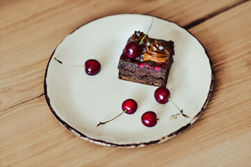 Chocolate cake with cherries on wooden background - obrazy, fototapety, plakaty