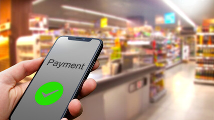 Payment with a smartphone using an online payment service in the grocery store, consumer, online banking, fintech, digitization, internet, contactless payment, shopping cart