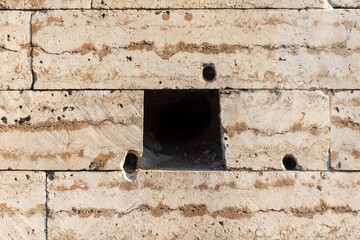 texture of a porous light brick with a square hole inside close up