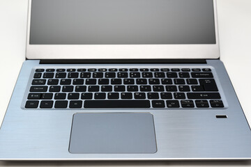 Keyboard of portable computer laptop with English layout and touchpad for online working and writing text.