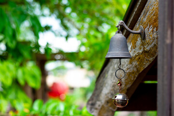 Steel bell hanging on the old wooden holder. (Selective focus)