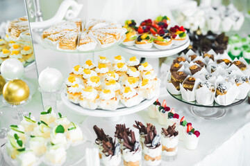Delicious sweets on wedding candy buffet with desserts, cupcakes
