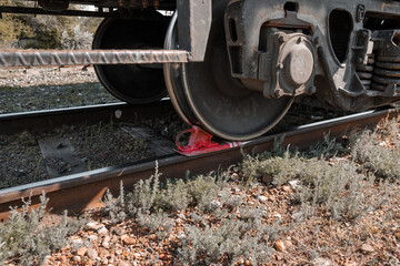 Close-up of a trolley for wagons on rails. The carriages are on the parking brake. A double-breasted brake shoe under the wagon wheel prevents the wagon from spontaneously moving downhill.