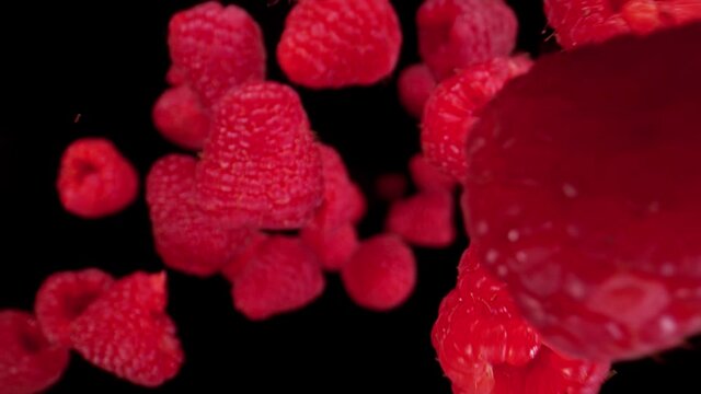Super Slow Motion Detail Shot of Flying and Rotating Fresh Raspberries at 1000fps.