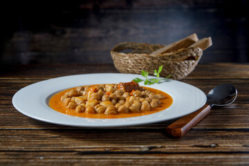 Chickpea stew dish, cocido madrileño. With beef, sausage (chorizo), bacon, carrots and bread.