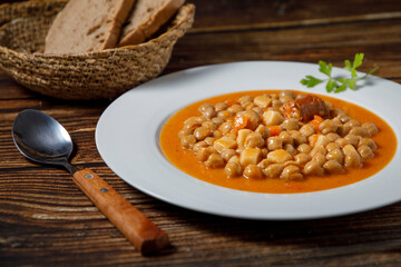 Chickpea stew dish, cocido madrileño. With beef, sausage (chorizo), bacon, carrots and bread.