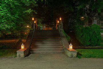 Park w mieście Iłowa w Polsce w nocnej scenerii. Ciemności rozświetlają lampiony ustawione na...