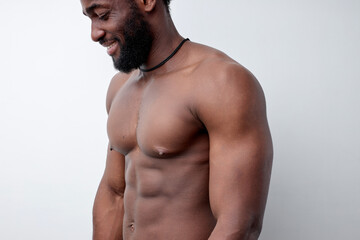 Fototapeta premium Cropped photo of strong muscular black man with naked torso, bodybuilder concept. Side view afro sportsman having strong abdominal abs. Close-up portrait, copy space. people, workout, sport, fitness